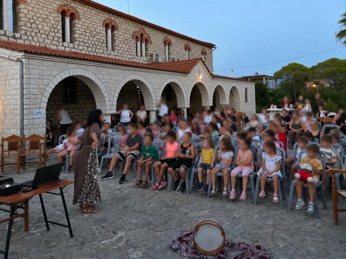 Η Παναγιώτα Στραγανιώτη αφηγείται σε μεγάλο κοινό παιδιών και γονέων έξω από εκκλησία, το βράδυ