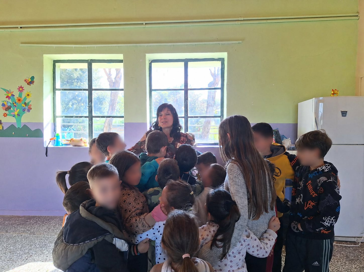 Παιδιά αγκαλιάζουν την Παναγιώτα Στραγανιώτη στο τέλος εκπαιδευτικού προγράμματος